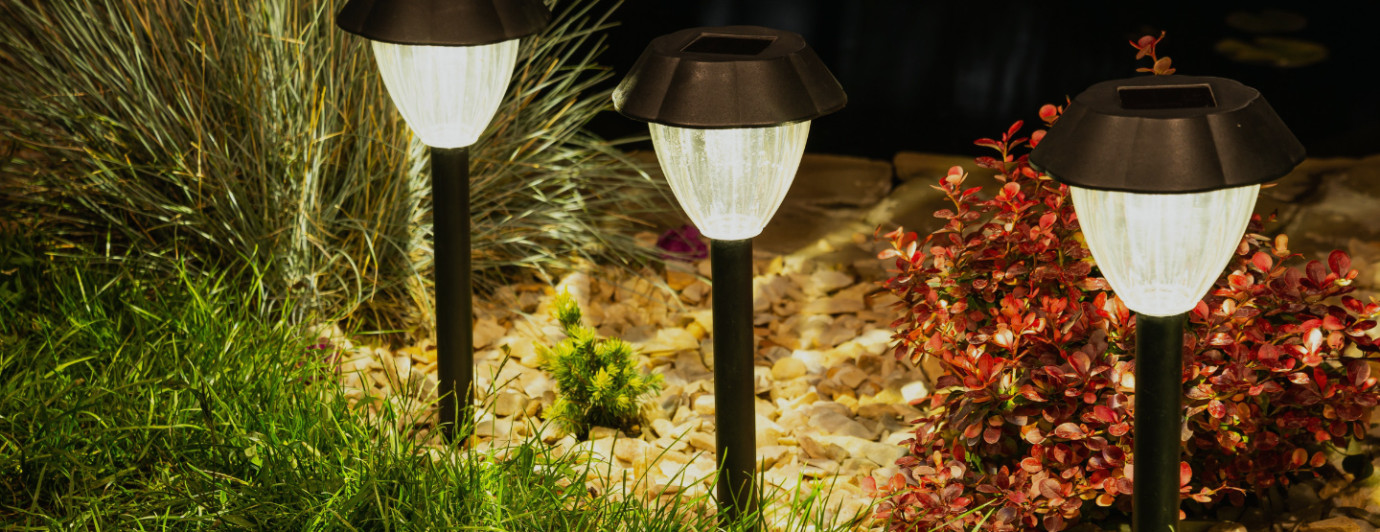 lampy solarne oświetlające chodnik w ogrodzie