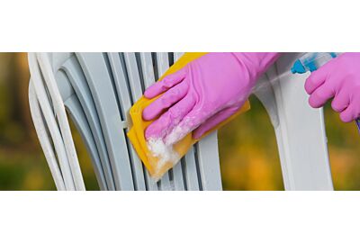 mężczyzna czyści zielone krzesło z plastiku