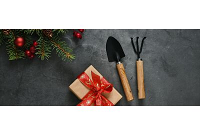 kobieta siedząca na tarasie z prezentami pod choinkę kupionymi na Black Friday