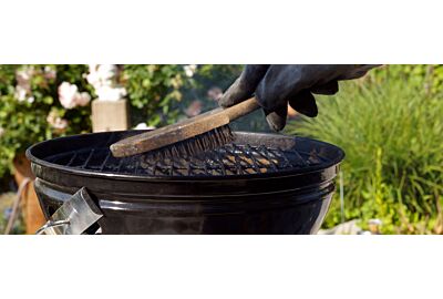 kobieta czyszcząca białą szmatką ruszt grilla elektrycznego