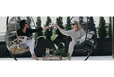 dwa fotele wiszące i kobietey celebrujące miłę popołudnie