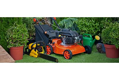 mężczyzna przycinający krzewy w ogrodzie nożycami elektrycznymi