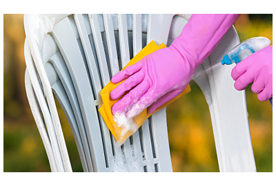 mężczyzna czyści zielone krzesło z plastiku