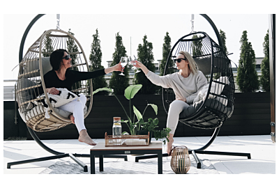 dwa fotele wiszące i kobietey celebrujące miłę popołudnie