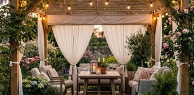 Pergola tarasowa z białymi zasłonami i girlandą świetlną