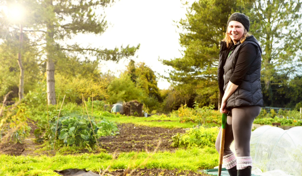 planowanie ogrodu, kobieta pracująca w ogrodzie późną jesienią z narzędziami ogrodowymi 