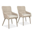 Dwa beżowe fotele ogrodowe z technorattanu, z podłokietnikami i poduszkami na siedziskach, ustawione obok siebie.