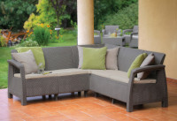 Zdjęcie narożnika ogrodowego CORFU RELAX Cappuccino, wykonanego z tworzywa sztucznego imitującego rattan, z jasnymi poduszkami na siedziska i ozdobnymi poduszkami na oparciach.