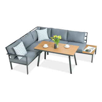 Narożny zestaw mebli ogrodowych z szarą sofą, drewnianym stołem i poduszkami w zygzak.