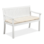 Biała drewniana ławka ogrodowa z kremową poduszką siedziska, widok z boku pod kątem.