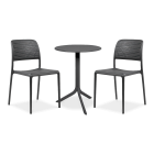 Zestaw kawowy do ogrodu, składający się z okrągłego stołu i dwóch krzeseł. Meble w kolorze grafitowym stoją na szarym tle. Blat stołu i oparcia krzeseł mają ażurowy, perforowany wzór, który dodaje zestawowi nowoczesności. Idealne meble ogrodowe na mały b