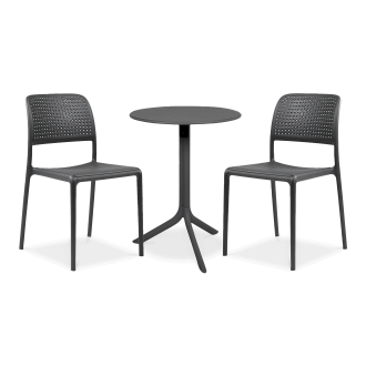 Zestaw kawowy do ogrodu, składający się z okrągłego stołu i dwóch krzeseł. Meble w kolorze grafitowym stoją na szarym tle. Blat stołu i oparcia krzeseł mają ażurowy, perforowany wzór, który dodaje zestawowi nowoczesności. Idealne meble ogrodowe na mały b