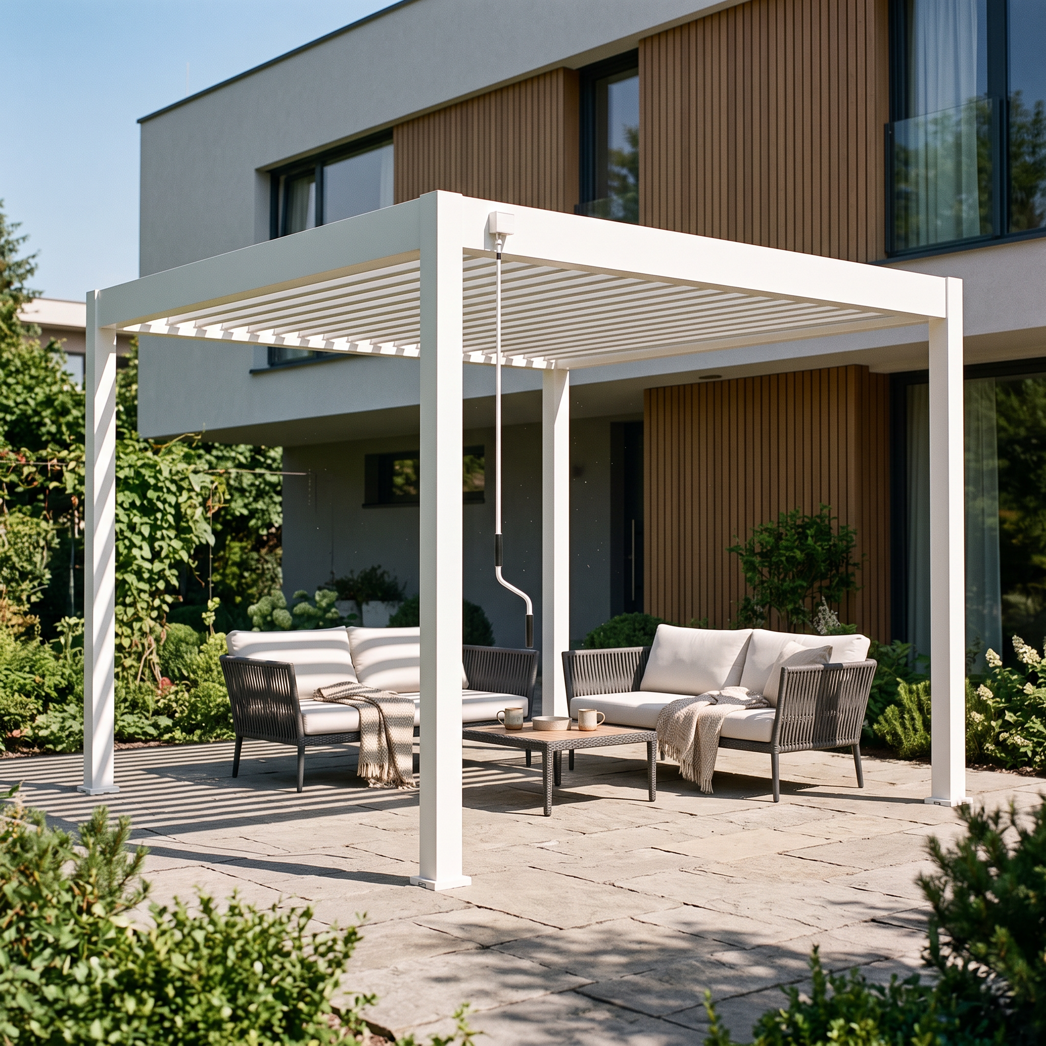 Biała pergola tarasowa Gutroof ELEGANCE 3x3 z zestawem wypoczynkowym na nowoczesnym tarasie przed domem