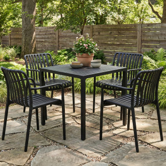 Czarny zestaw mebli ogrodowych z kwadratowym stołem i czterema krzesłami na kamiennym tarasie