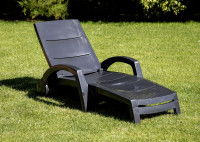 Leżak ogrodowy ocean w kolorze antracytowym na ogrodzie w słoneczny dzień