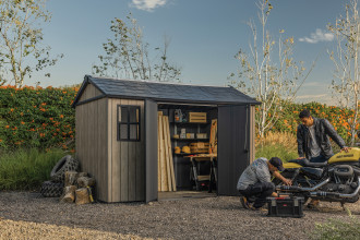 Domek narzędziowy Keter DECO APEX 7511/1175 Ashwood w naturalnym otoczeniu z motocyklem