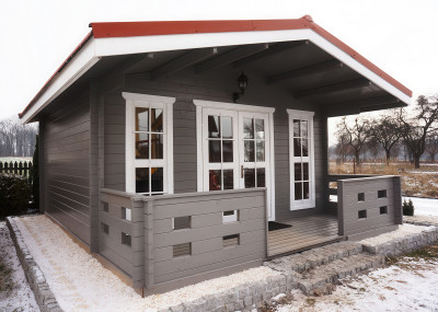 przód parterowego drewnianego domku skadi pomalowanego w kolor szary z białym ościeżnicami okien i czerwonym dachem