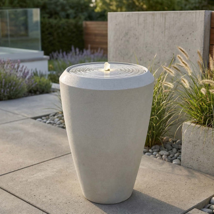 Fontanna ogrodowa jasna w aranżacji ogrodowej przy ścieżce i donicach z roślinami