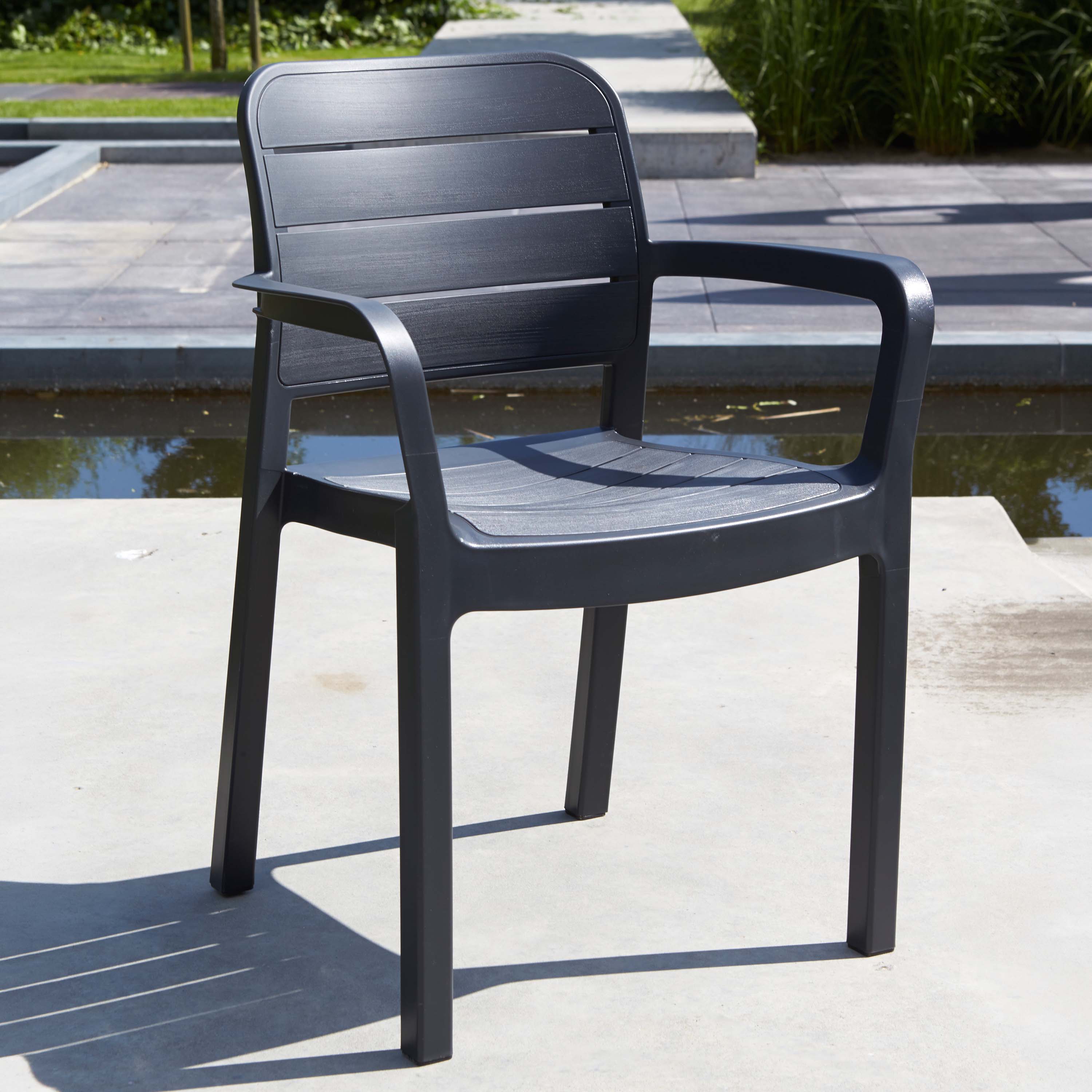 Krzesło ogrodowe grafitowe z podłokietnikami na tarasie przy oczku wodnym widok bliższy aranżacja ogrodowa
