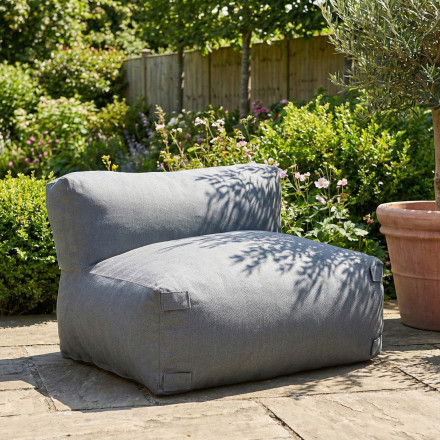 Moduł środkowy sofy modułowej w ogrodowej aranżacji z zielenią