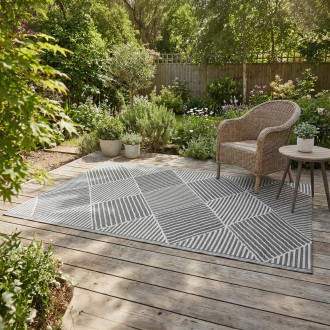 Szary dywan tarasowy z geometrycznym wzorem w aranżacji ogrodowej na drewnianym tarasie