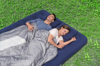 Wizualizacja dwóch śpiących osób na materacu na trawie