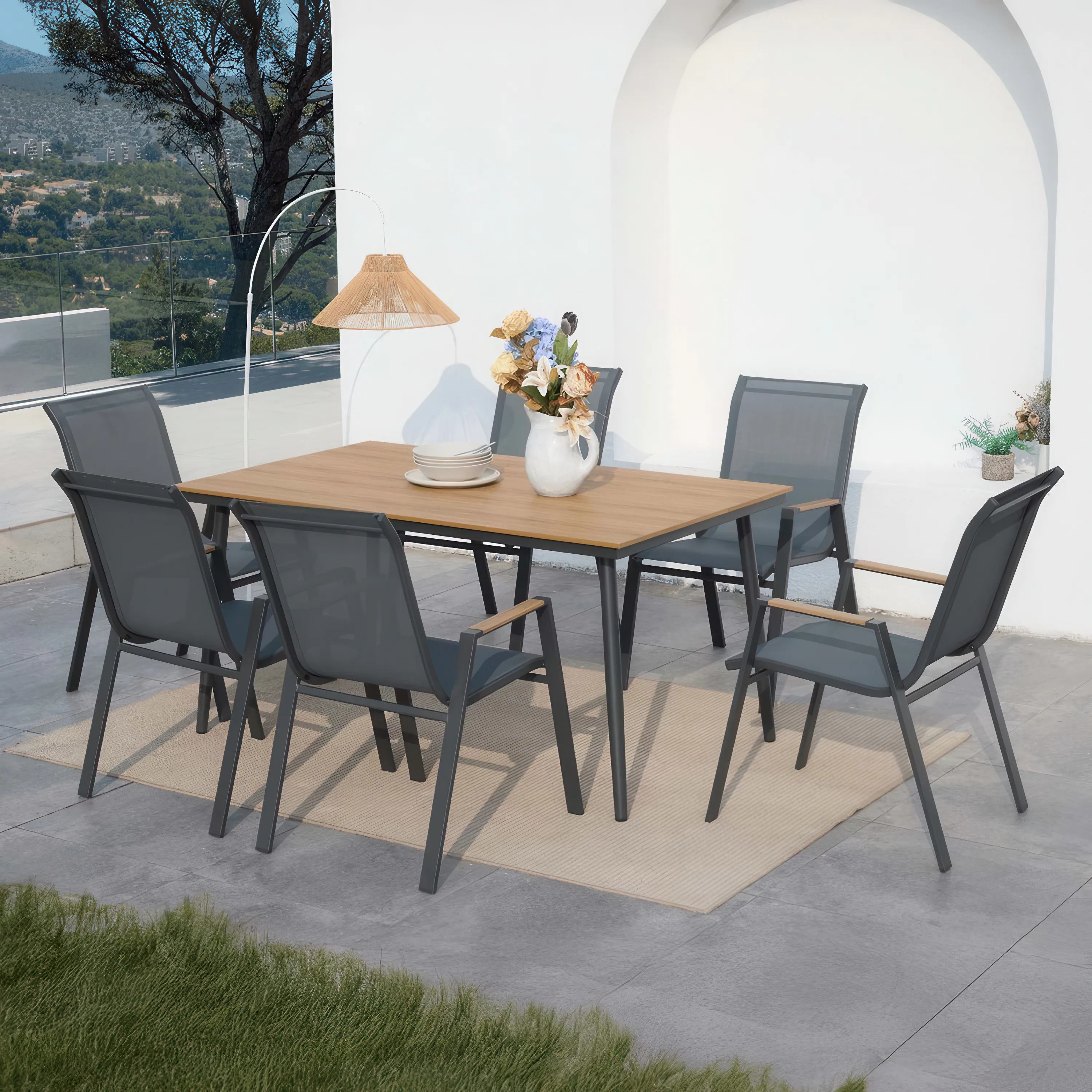 Zestaw mebli jadalnianych NOVA DINING 6+1 Dark Grey - aranżacja na tarasie, jasny dywan pod zestawem, dzbanek z kwiatami na stole