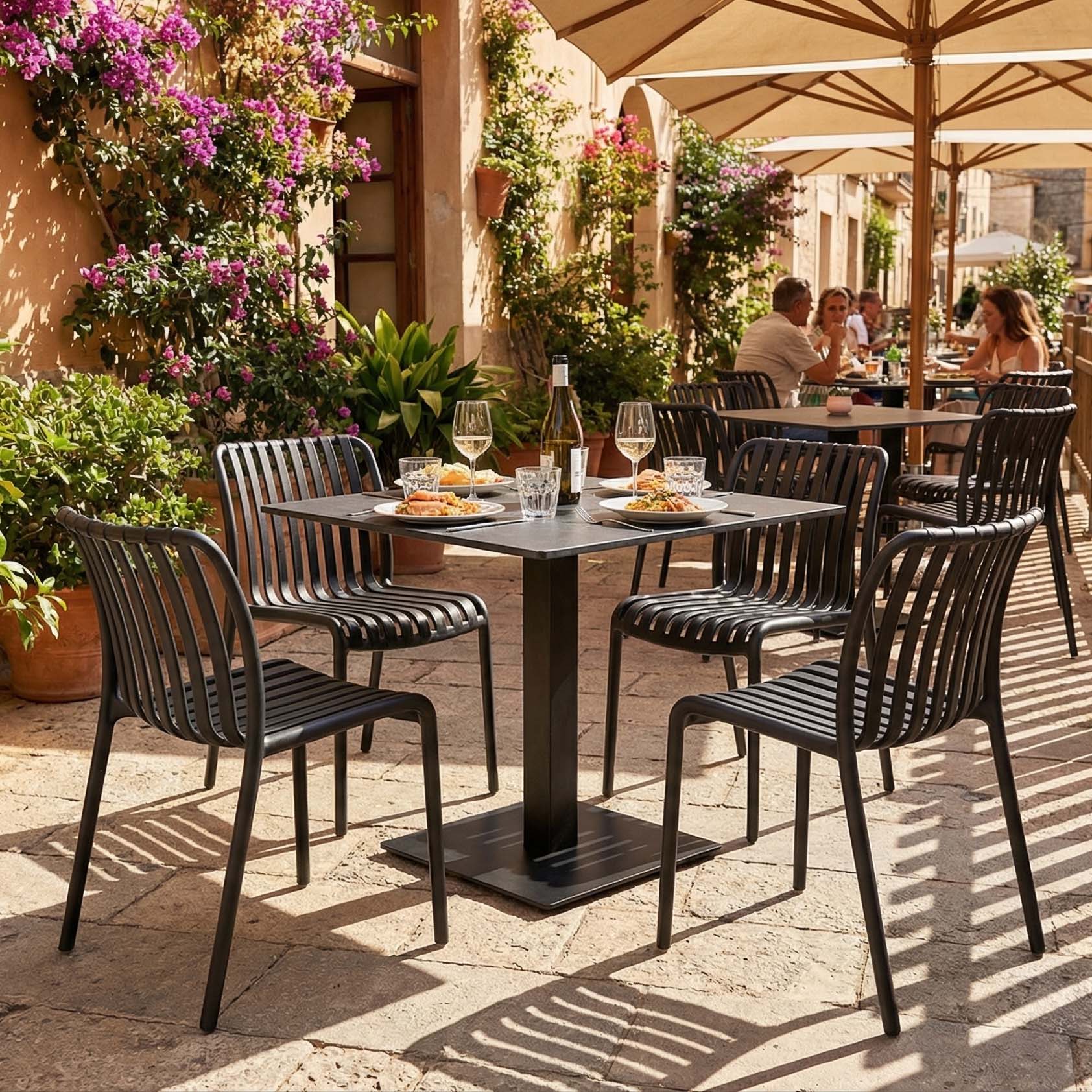 Zestaw mebli ogrodowych czarny stół i krzesła na słonecznym tarasie aranżacja
