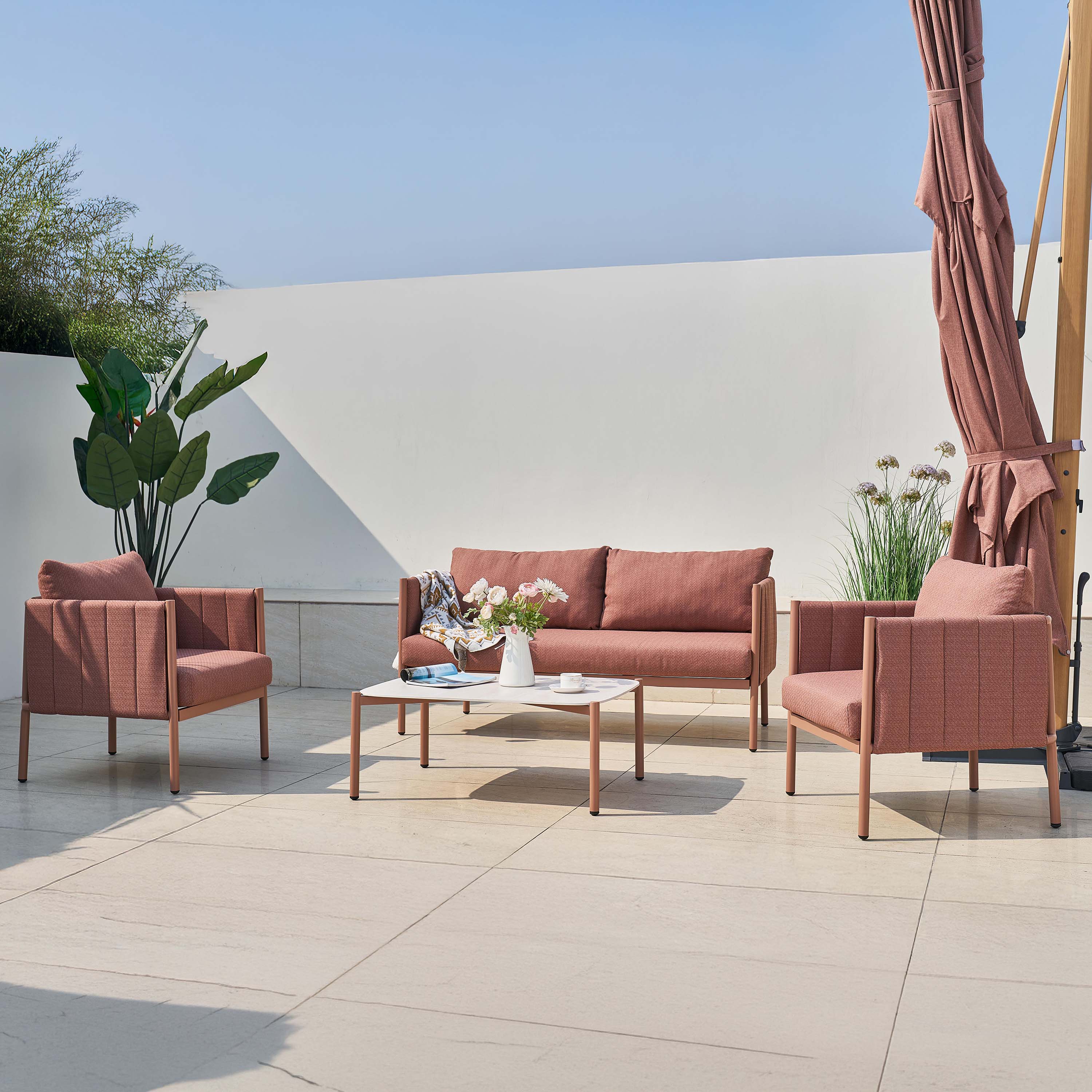 Zestaw mebli ogrodowych z sofą i fotelami w kolorze kawowym ustawiony na tarasie w aranżacji