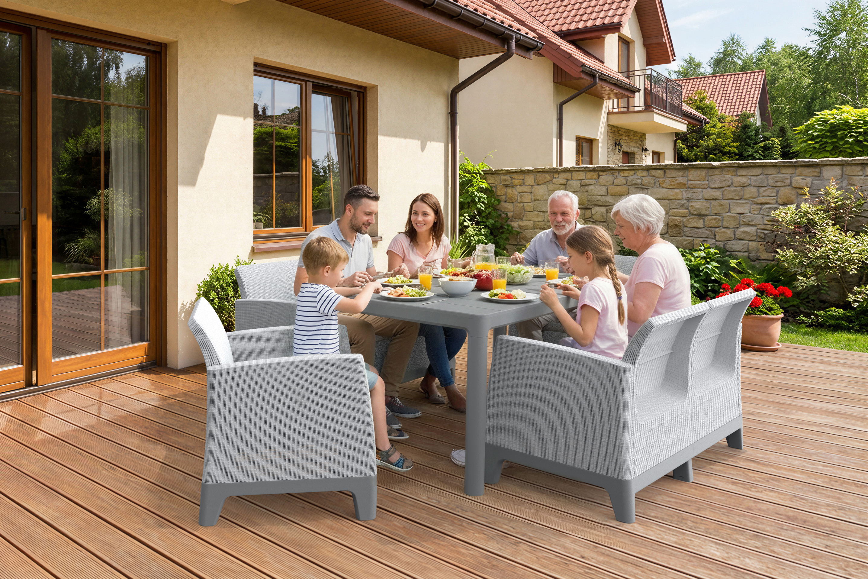 Zestaw mebli ogrodowych SCANDI DINING FIESTA Ash Grey-Storm Grey z rodziną przy stole na tarasie