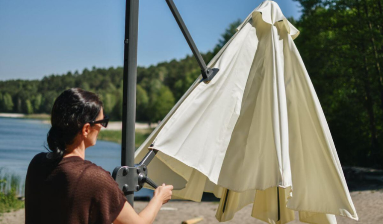 kobieta rozkładająca parasol do wyschnięcia 