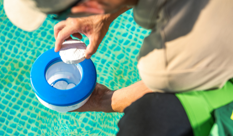 meżczyzna wkładający chlor w tabletce do basenu 