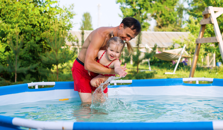 mężczyzna z córką w basenie stelażowym
