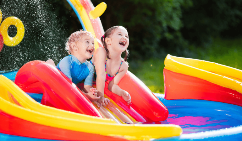 dzieci bawiące się w dmuchanym basenie w ogrodzie 