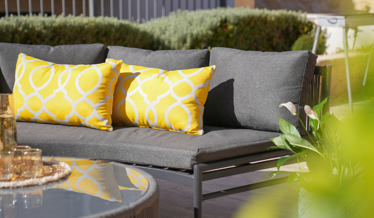 ż&oacute;łte poduszki z tkaniny sunbrella na antracytowych meblach ogrodowych