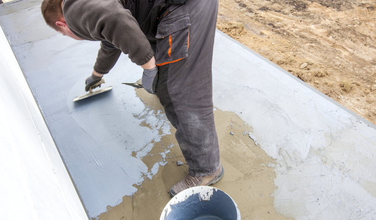 robotnik r&oacute;wnachący posadzkę na taras betonowy 