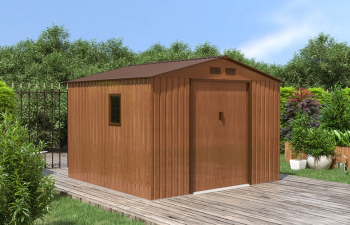 brązowy domek ogrodowy ustawiony w ogrodzie na utwardzonym podłożu 