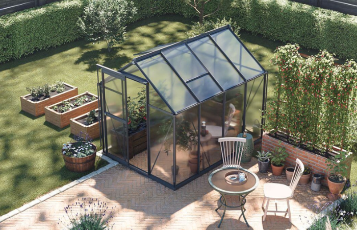 wytrzymala, nowoczesna szklarnia poliweglanowa do uprawy roslin ustawiona obok domu jednorodzinnego 