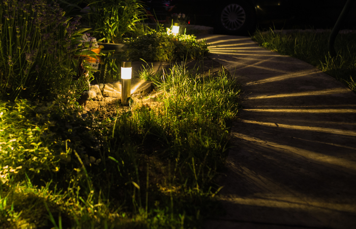  latarnie w klombach oświetlające ścieżkę w ogrodzie 