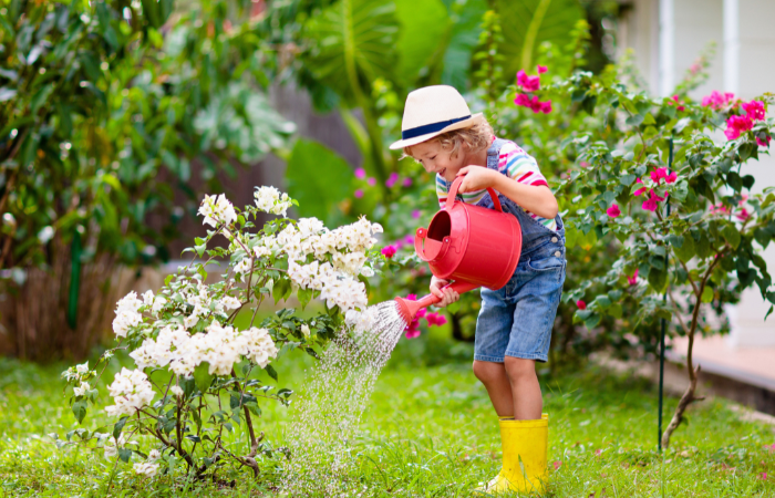  Dziecko opiekujące się roślinami i kwiatami w ogrodzie