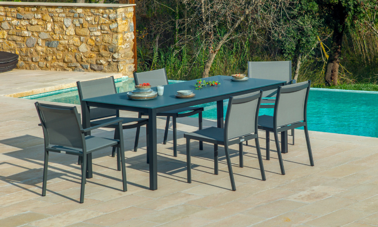 antracytowy zestaw mebli jadalnianych ustawiony przy basenie w ogrodzie 