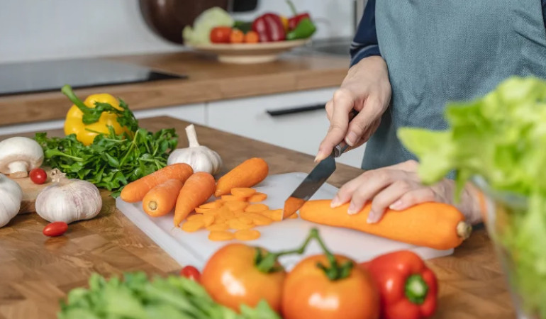 kobieta kroi marchew w kuchni