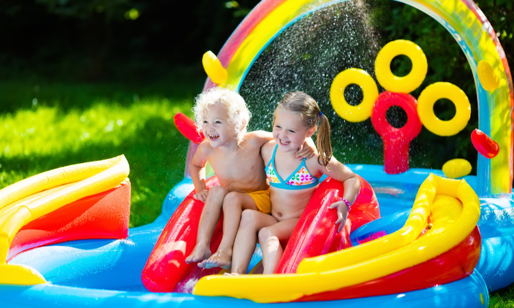 Dzieci bawiące się w nadmuchiwanym basenie dla dzieci. 