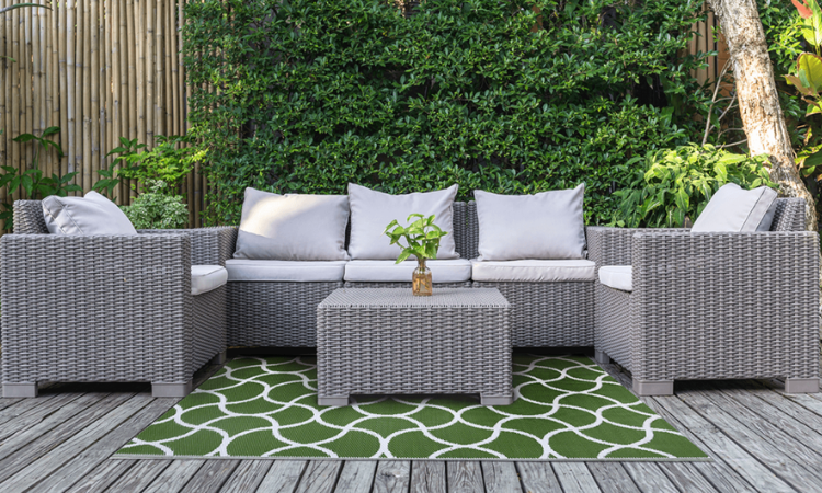zielony biały dywan tarasowy z meblami z technorattanu 