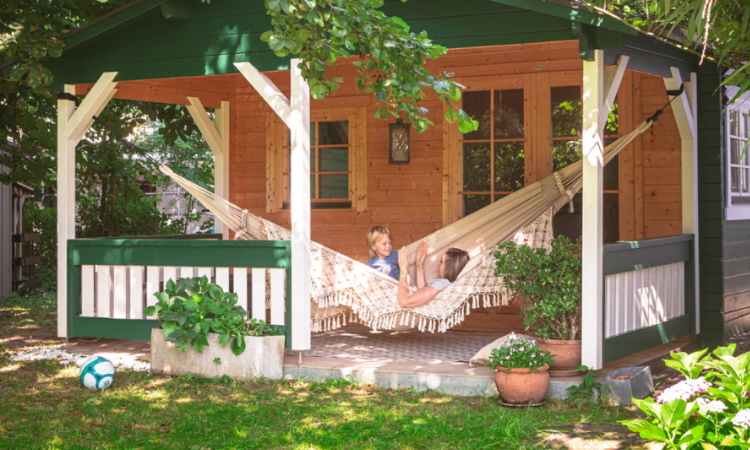 kobieta z dzieckiem wypoczywająca na hamaku zamocowanym na tarasie w altanie