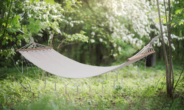 beżowy hamak z frędzlami w ogrodzie