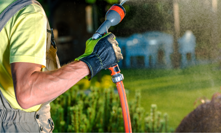 ogrodnik podlewający ogr&oacute;d
