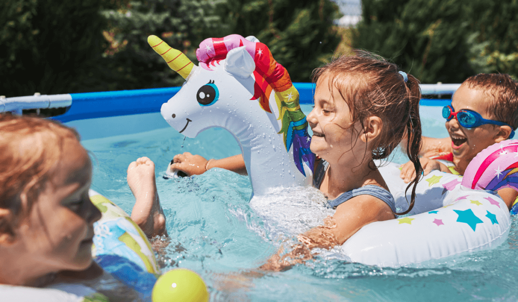 Tr&oacute;jka dzieci bawiąca się w basenie