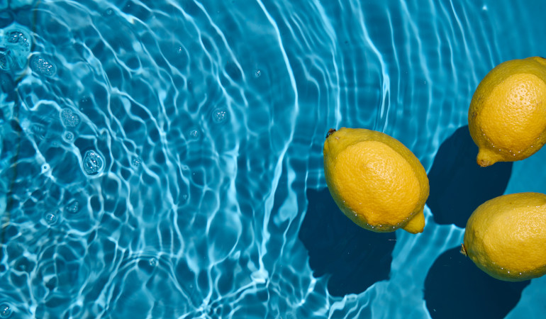Trzy cytryny unoszące się na tafli wody basenu