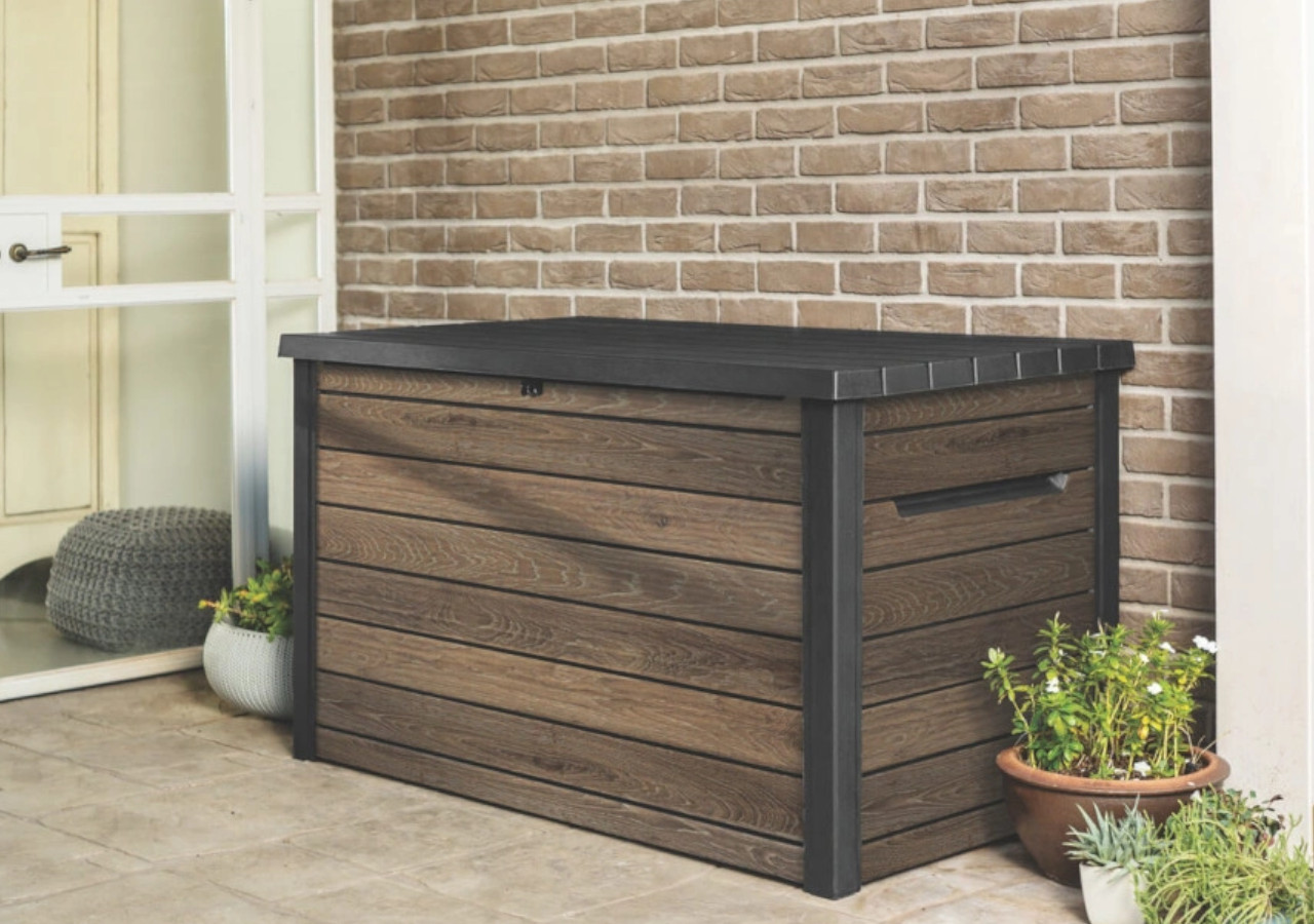Drewnopodobna skrzynia ogrodowa z czarną pokrywą przy ścianie tarasu